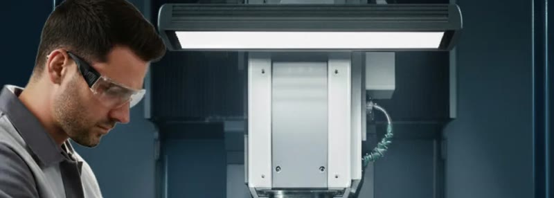 Mitarbeiter an einer CNC-Maschine, beleuchtet von einer LED-Maschinenleuchte